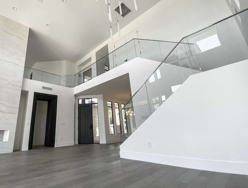 Glass railing on stairs from the main level of a house to the upstairs