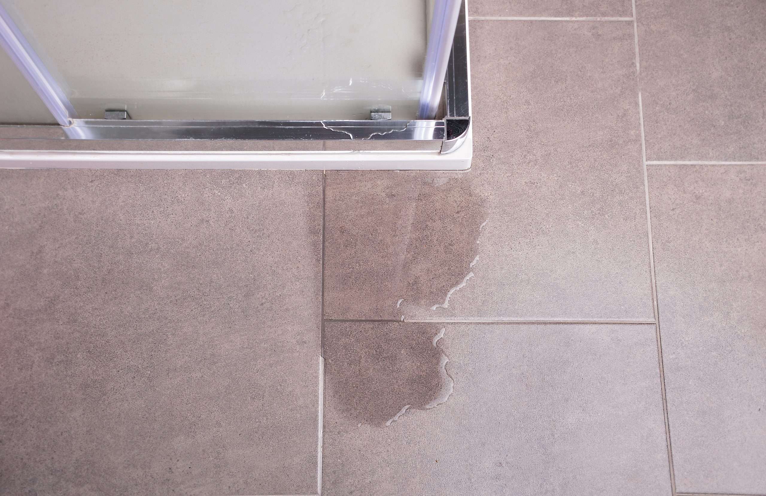 Leakage of water from a shower cabin with glass wall that is damaged