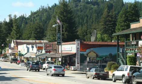 Small mountain town street with shops and cars