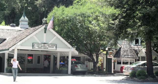 Historic inn surrounded by trees and parked cars