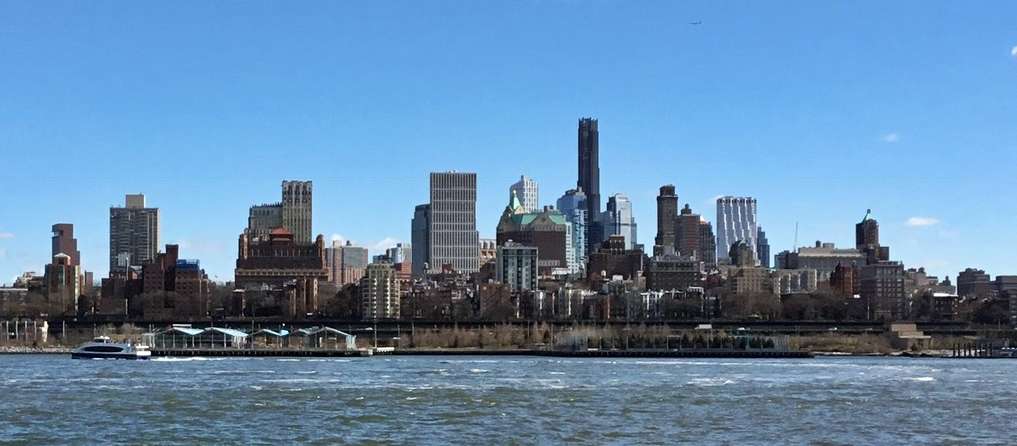 City skyline with waterfront buildings under blue sky